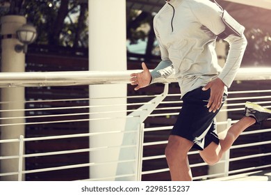 Running will make your body stronger. an unrecognizable man running on a bridge in the city.