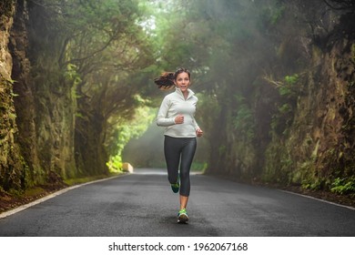 Running woman in autumn forest training on cold morning. Outdoor sport Asian girl athlete runner jogging outside fitness winter motivation. - Powered by Shutterstock