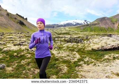 Running woman exercising - trail runner athlete. Fit female sport fitness model training jogging outdoors living healthy lifestyle in beautiful mountain nature, Snaefellsjokull, Snaefellsnes, Iceland.