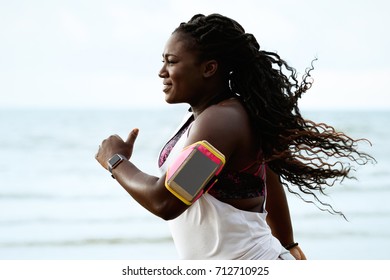 Running Woman. Female African Runner Jogging During Outdoor Workout On Beach Under Rain