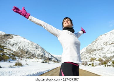 Running Woman Success Bliss Sport Concept On Winter Road Mountain Background. Beautiful Cheerful Caucasian Female Athlete With Arms Up.