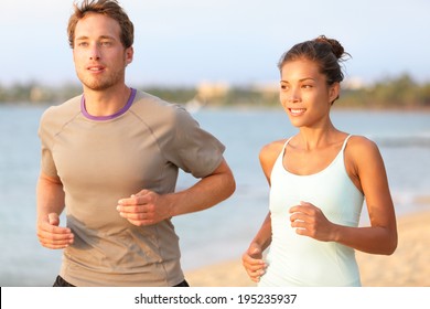 Running Young Pretty Couple Jogging On Summer Beach Sand In Sun. Exercising Caucasian Fitness Model And Beautiful Mixed Race Female Sports Model In 20s Working Out Outdoors Living Healthy Lifestyle.