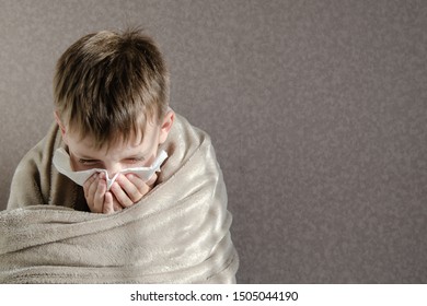 Runny Nose, Respiratory Virus. Little Kid Boy Blows Nose Into A Paper Handkerchief