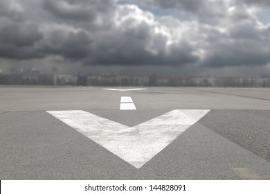 Runway Airport With Arrow And  Storm Clouds