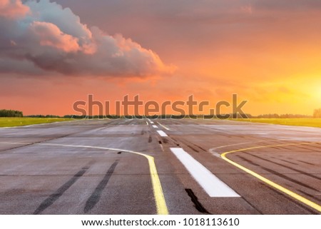 Runway at the airport the horizon at sunset in the center of the sun