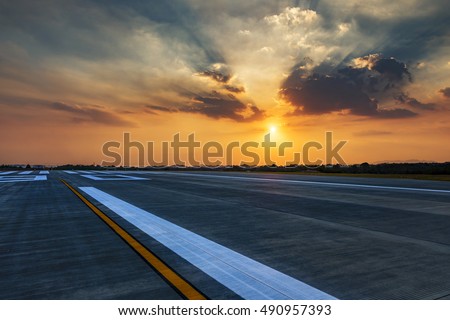Runway, airstrip in the airport terminal with marking in sunset background. Travel aviation concept.