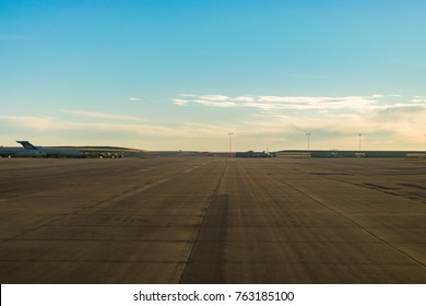 Runway with planes parked on it in the distance