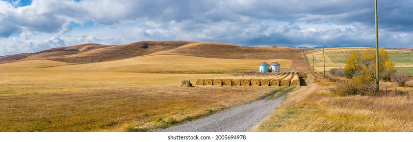 Rural Alberta Canadian prairie grassland landscape countryside background panorama. Beautiful farmer's field and grain silos with hay bales wallpaper 