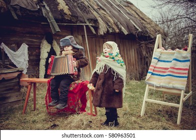 Rural Boy In Old Clothes Playing The Accordion. Village Girl Singing. 