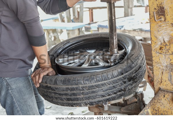 Rural car repairman in Thailand replaced tire on
car repair.