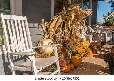 Rural Country Home Porch With White Chairs, Decorated With Pumpkins, Corn Stalks And Flowering Chrysanthemums For Autumn And Thanksgiving Holidays. 