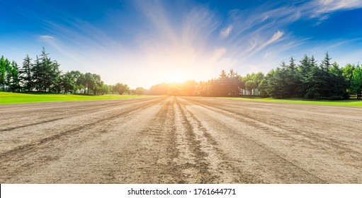 Rural Dirt Road Ground And Green Forest At Sunrise.