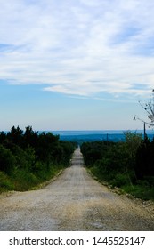 Rural Dirt Road In Texas Landscape, Middle Of Nowhere In The Country.  Scenic Travel Path Through Trees.