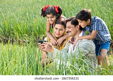 Rural Family Using Mobile Phone On Agriculture Field