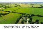 Rural farmland to horizontal lines in Fairland, Oklahoma, center pivot irrigation water energy-efficient with pipeline mobile truss structures motorized wheels move through field, aerial view. USA