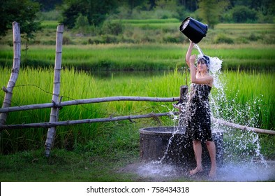 Rural Girl Is Taking A Shower From A Traditional Groundwater At Countryside.