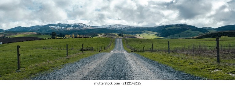Rural gravel road on a farm, beautiful view of the snowy hills. New Zealand, canterbury