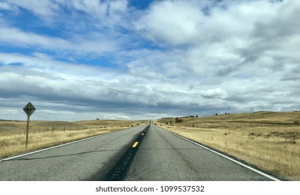 Rural Highway In Northern Montana With Cows Crossing The Road In The Background