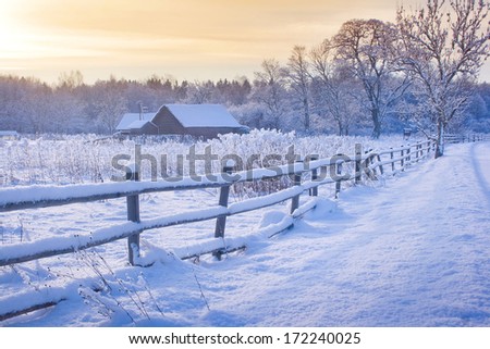 Rural house with a fence in winter