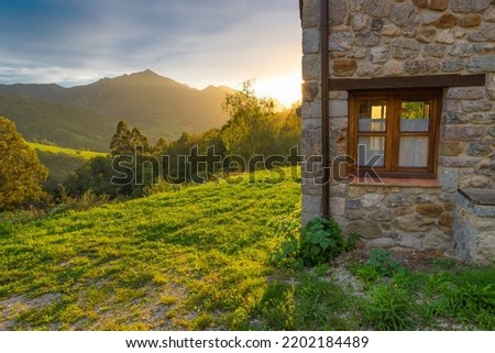 Rural house made of stone and wood in the mountains at sunset. Secluded cabin vacation rental. Country getaway. Asturias, Spain.