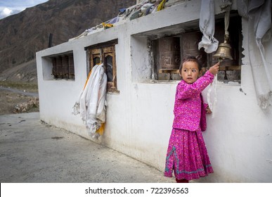 rural indian girl child is playing with prayer bells in a chorten near kaza, himachal pradesh, india
