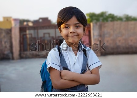Rural Indian school girl stanging crossed arms