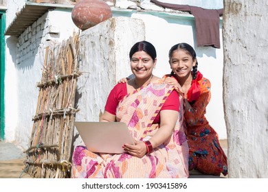 Rural Indian Woman with daughter using laptop at village