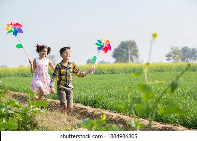 Rural kids playing in  agricultural field with windmill - Shutterstock ID 1884986305