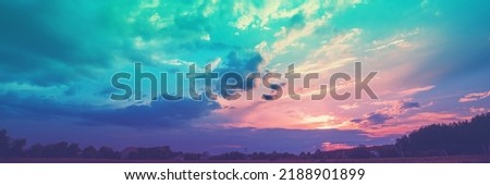 Rural landscape with beautiful gradient evening sky at sunset. Silhouette of houses against the sky. horizontal banner