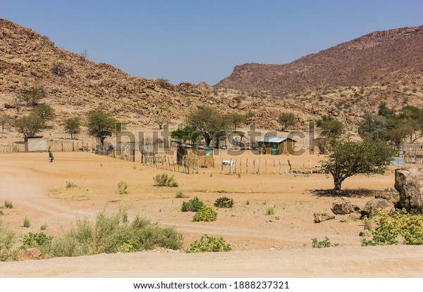 rural landscape\
scene in Namibia of clay huts and a small human settlement in the\
harsh arid environment 
