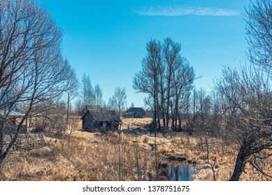 Rural Landscape With A Small River And Abandoned Rural Buildings In Backlit