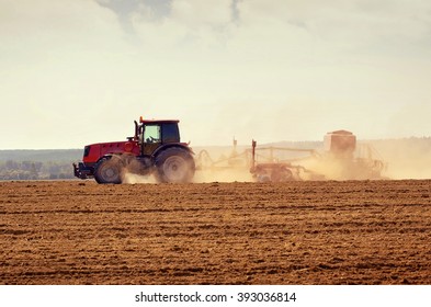 Rural Landscape With  Tractor In The Field During Sowing Grain