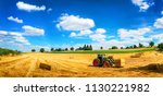 Rural landscape in vivid blue and yellow, with a tractor working, blue sky and a harvested gold field