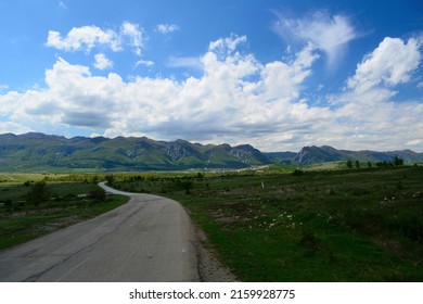 Rural northwestern Bulgaria in early spring. Country road in Bulgaria , Balkan mountains (Vratsa Balkan part of Stara planina) mountain in background.