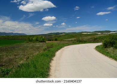 Rural northwestern Bulgaria in early spring. Country road in Bulgaria , Balkan mountains (Vratsa Balkan part of Stara planina) mountain in background.