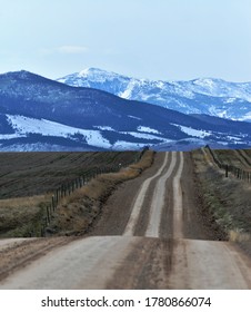 Rural road points toward the distant Elkhorn mountains in western Montana.