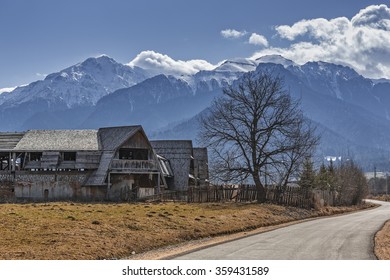 Rural scenery with old abandoned wooden farmhouse in the valley of snowy Bucegi mountains, Brasov county, Romania.