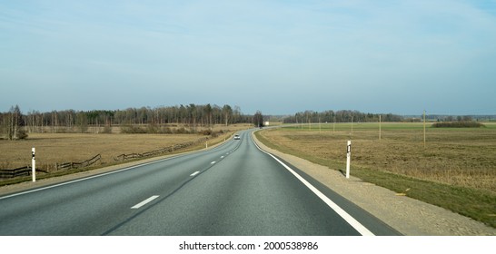 Rural, Shallow Highway Route Leading To Horizon With Few Cars.