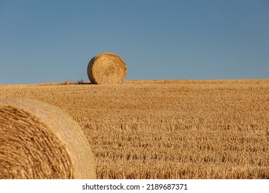 A Rural South Downs Summer Landscape, With Hay Bales In A Newly Harvested Field