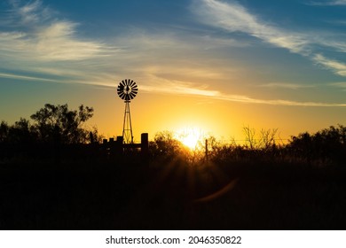 Rural sunrise with windmill and clouds