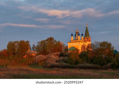 Rural sunset view of Dunilovo town with ancient church, traditional houses, field and trees. Russia. - Powered by Shutterstock