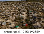 Rural, township and poverty with shacks, houses or informal settlement of land or squatter camps in South Africa. Aerial view of village, housing or poor infrastructure of town or developing country