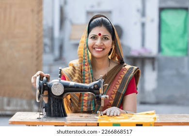 Rural woman sewing clothes with sewing machine at home. - Powered by Shutterstock