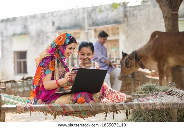 Rural woman using\
laptop with her daughter.