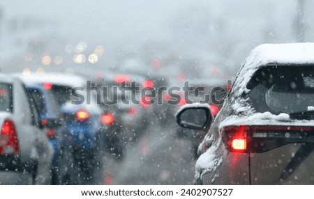 Rush hour traffic because of a winter snowfall. Photo in standstill traffic, massive snowfall. Transportation industry.