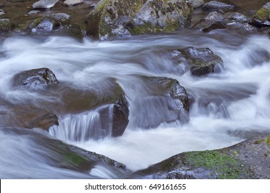 Rushing River Water Flowing Over Rocks In Oregon