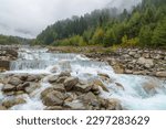 Rushing water and small rapids over and around rocks in canyon river rocky stream. Beautiful spring and summer nature landscapes and fog