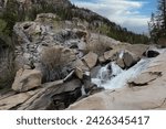 A rushing waterfall through craggy rocks on The Grottos Trail in th White River National Forest, in Colorado, USA