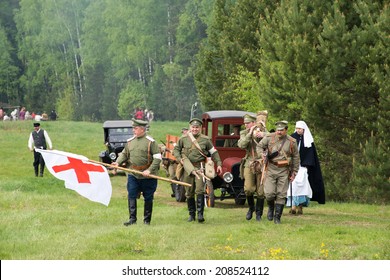 RUSSIA, CHERNOGOLOVKA - MAY 17: Unidentified Men With Medicine Red Cross Flag Walk To Hospital Place On History Reenactment Of Battle Of Civil War In 1914-1919 On May 17, 2014, Russia