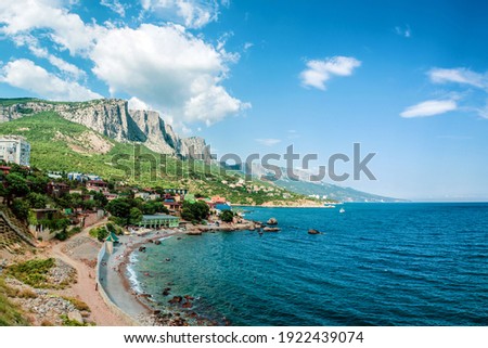 Russia, Crimea, Foros resort town panoramic aerial view, wide angle. Beach with vacationers. Beautiful mountain range, plateau and valley scenery. Rocks and mountain peaks landscape